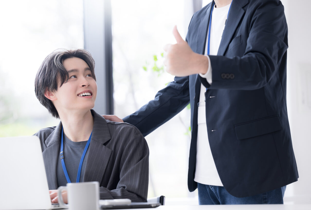 スタッフが肩に手を添えて励ましている様子